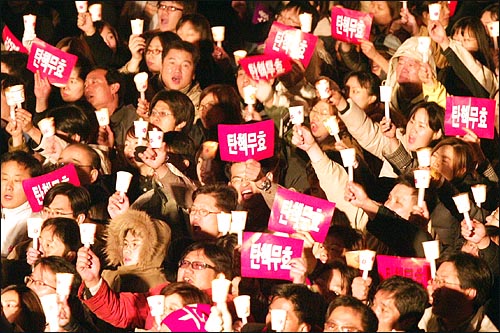 지난 3월20일 서울 광화문 네거리 일대에서 열린 '탄핵무효와 민주수호를 위한 100만인대회'에 참석한 시민들이 촛불과 함께 '탄핵무효'라고 적힌 붉은색 카드를 흔들고 있다. 